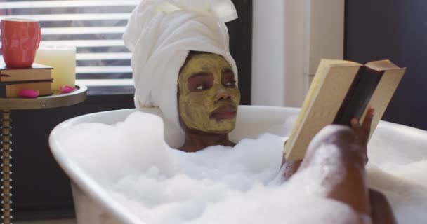 Mujer Afroamericana Con Toalla Máscara Tomando Baño Leyendo Libro Baño — Vídeo de stock