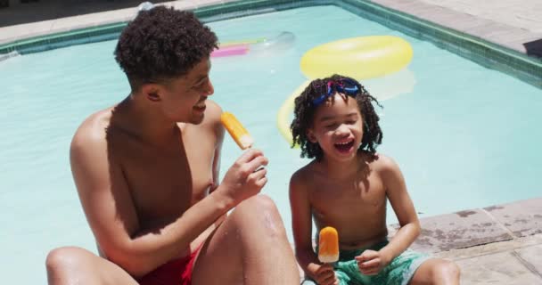 Gelukkige Biracial Man Zijn Zoon Eten Ijsjes Bij Het Zwembad — Stockvideo