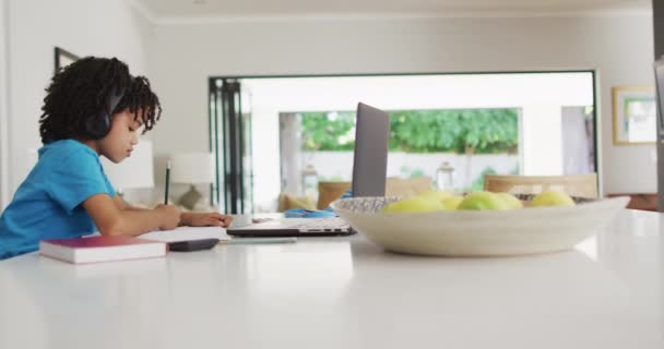 Szczęśliwy Dwurasowy Chłopak Siedzący Przy Stole Laptopem Mający Zajęcia Online — Wideo stockowe