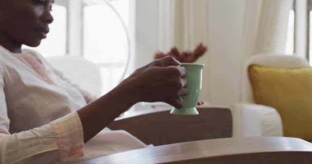 Mulher Americana Africana Feliz Sentada Poltrona Sala Estar Bebendo Café — Vídeo de Stock