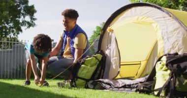 Mutlu melez adam ve oğlu bahçede çadır kuruyor. ev hayatı, evde zaman geçirmek..