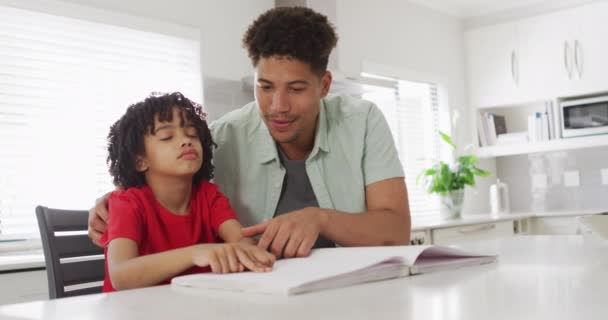 Lycklig Biracial Man Och Hans Son Läser Punktskrift Tillsammans Hushållsliv — Stockvideo