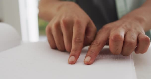Sección Media Del Hombre Biracial Sentado Mesa Cocina Leyendo Braille — Vídeo de stock