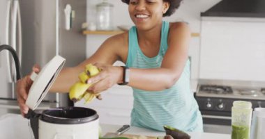Mutlu Afro-Amerikan kadın temizlik yapıyor, mutfağa atıkları atıyor. ev hayatı, evde boş zaman geçirmek..