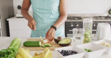 Afro-Amerikan kadının orta kesimi mutfakta sebze kesiyor. ev hayatı, evde boş zaman geçirmek..