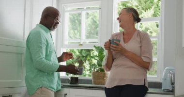 Gömlek giyip mutfakta kahve içen mutlu kıdemli çift. Evde birlikte vakit geçirmek..