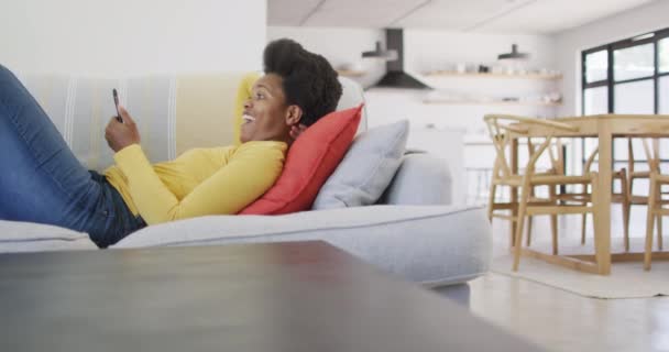 Mujer Afroamericana Feliz Acostada Sofá Usando Teléfono Inteligente Estilo Vida — Vídeos de Stock