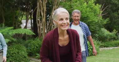 Bahçede Amerikan futbolu oynayan mutlu kadın ve erkek son sınıf arkadaşlarının animasyonu. Emeklilik yaşam tarzı, arkadaşlarla kaliteli zaman geçirme.