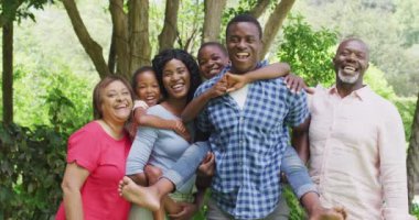 Mutlu Afro-Amerikan çoklu kuşak ailesi bahçede poz veriyor. Aile, birliktelik ve dışarıda kaliteli zaman geçirmek..