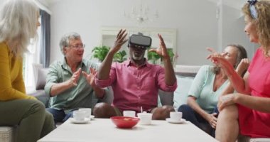Çeşitli kadın ve erkek kıdemli arkadaşların video kulaklığı takıp eğlenmesi. emeklilik yaşam tarzı, arkadaşlarla ve teknolojiyle kaliteli zaman geçirme.
