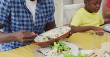Afro-Amerikan babanın evde ailesiyle yemek yemesi ne güzel. Aile, birliktelik ve evde kaliteli zaman geçirme.