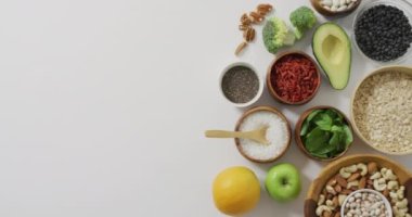 Taze avokado, brokoli, elma ve fotokopi alanı olan bitki içerikli kaseler. Taze vejetaryen yemeği, sağlıklı beslenme konsepti dijital olarak üretilen video..