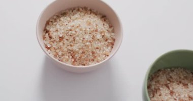 Himalaya tuzunun beyaz arka planda seramik kaselerde videosu. yemek ve yemek malzemeleri konsepti.