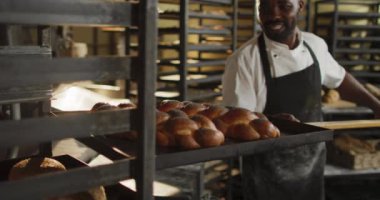 Mutlu Afro-Amerikan erkek fırıncının ahşap spatulasını challah ile tutmasının animasyonu. Pastanede çalışmak, bağımsız küçük işletme.