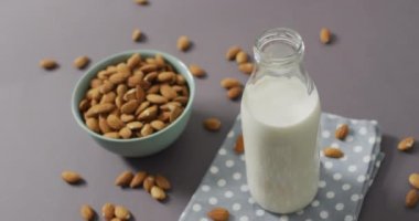 Gri arka planda bir kasede taze badem videosu. Taze vejetaryen yemeği, bitki temelli diyet, sağlıklı beslenme konsepti.