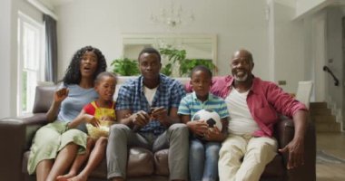 Mutlu Afro-Amerikan ailesi TV 'de maç izlerken tezahürat yapıyor. aile, birliktelik, spor ve evde kaliteli zaman geçirme.