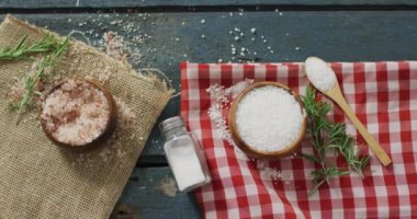 Biberiye dalı videosu ve ahşap arka planda bir kaşık tuz. yemek ve yemek malzemeleri konsepti.