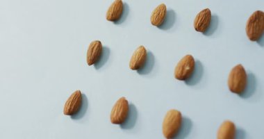 Mavi arka planda badem videosu. Taze vejetaryen yemeği, bitki temelli diyet, sağlıklı beslenme konsepti.
