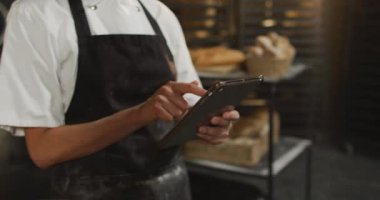 Tablet kullanan Asyalı fırıncı kadın ellerinin animasyonu. Fırında teknolojiyle çalışmak, bağımsız küçük işletmeler..