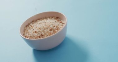 Mavi arka planda organik tuz kasesinin yakın plan görüntüsü. yemek ve yemek malzemeleri konsepti.