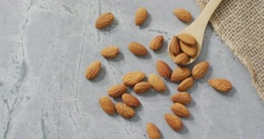 Arkaplanda badem videosu var. Taze vejetaryen yemeği, bitki temelli diyet, sağlıklı beslenme konsepti.