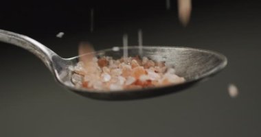 Aşçının siyah arka planda masaya tuz attığı video. yemek ve yemek malzemeleri konsepti.