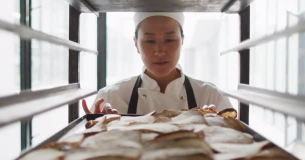 Animering Glad Asiatisk Kvinnlig Bagare Kontrollera Nyberedda Rullar Arbetar Bageri — Stockvideo