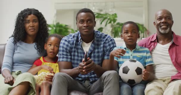 テレビで試合を見ながら 幸せなアフリカ系アメリカ人家族の応援 スポーツ 家庭での質の高い時間を過ごすこと — ストック動画