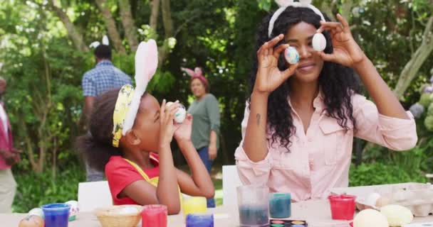 Animation Happy African American Mother Daughter Painting Easter Eggs Outdoors — Vídeo de stock