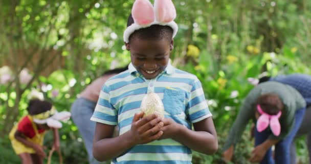 Animation Happy African American Boy Holding Easter Egg Garden Family — Vídeo de Stock