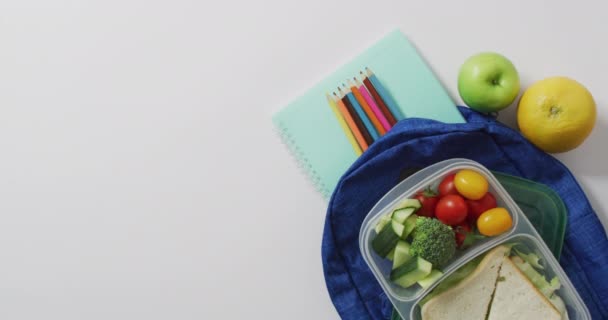 Wideo Zdrowym Zapakowanym Obiadem Owoców Warzyw Kolorowymi Ołówkami Torbie Szkolnej — Wideo stockowe