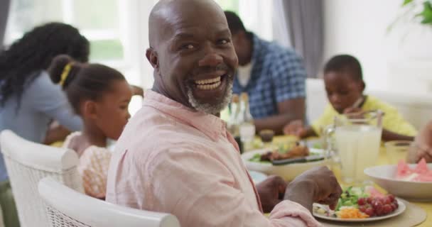 幸せなアフリカ系アメリカ人の祖父は自宅で家族と昼食を食べています 家族みんなで家で質の高い時間を過ごし — ストック動画