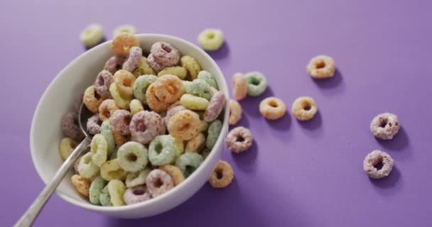 彩色早餐谷物与碗和勺子紫色背景的视频 早餐食品和烹调配料概念 — 图库视频影像