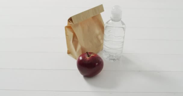 紙のランチバッグのアニメーション青の背景に果物 新鮮なビーガンフード 植物ベースの食事 健康的な食事のコンセプト — ストック動画