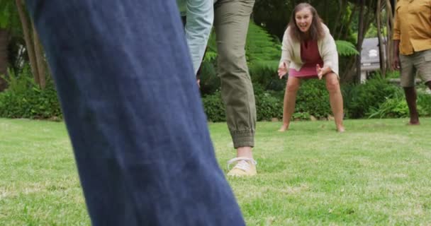 庭でアメリカンフットボールをしている幸せな多様な女性と男性の先輩の友人のアニメーション 退職生活 友人との時間を過ごすこと — ストック動画