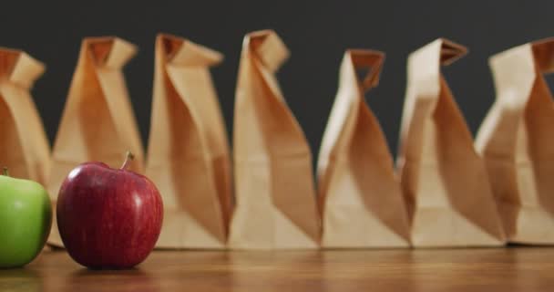 紙のランチバッグのアニメーション木製のテーブルの上に果物 新鮮なビーガンフード 植物ベースの食事 健康的な食事のコンセプト — ストック動画