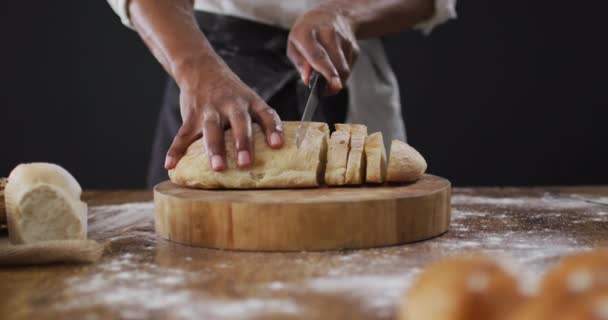厨师在黑色背景下切面包的视频 食物及烹调配料概念 — 图库视频影像