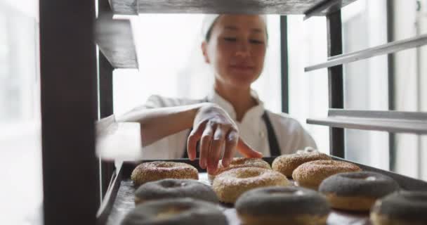 Animation Einer Glücklichen Asiatischen Bäckerin Die Frisch Zubereitete Krapfen Prüft — Stockvideo