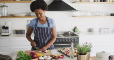 Afro-Amerikan kadın mutfakta yemek hazırlıyor. ev hayatı, evde boş zaman geçirmek..