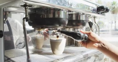 Afro-Amerikan erkek baristanın orta bölümü kafede kahve yapıyor. Küçük bağımsız kafe işletmesi.