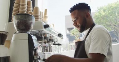 Kafede kahve makinesiyle kahve yapan Afro-Amerikan erkek kahveci. Küçük bağımsız kafe işletmesi.