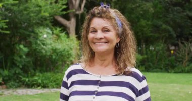 Bahçedeki kameraya gülümseyen son sınıf melez kadının animasyonu. Emeklilik hayatı, dışarıda boş zaman geçirmek..