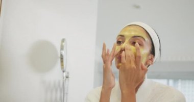 Beyaz kadın aynaya bakıyor ve banyoda makyaj yapıyor. Evde yalnız zaman geçirmek..