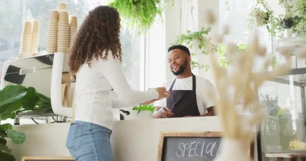 幸せなアフリカ系アメリカ人男性バリスタは カフェで出産女性のクライアントのためのコーヒーを作る 小さな独立系カフェビジネス — ストック動画