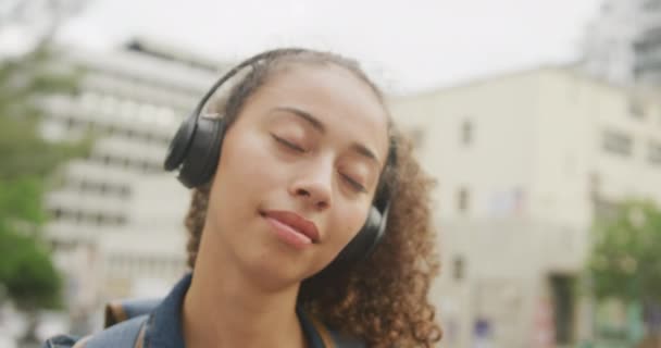 Счастливая Расовая Женщина Городе Наушниках Улыбающаяся Цифровая Реклама Ходу Улице — стоковое видео