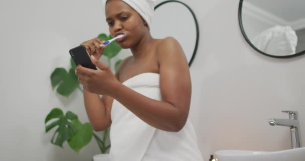아프리카 미국인 화장실에서 양치하고 스마트폰을 사용하는 행복하게 합니다 에서의 집에서의 — 비디오