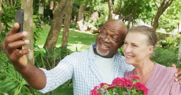 Šťastný Seniorský Pár Tričkách Selfie Smartphonem Zahradě Trávit Spolu Čas — Stock video