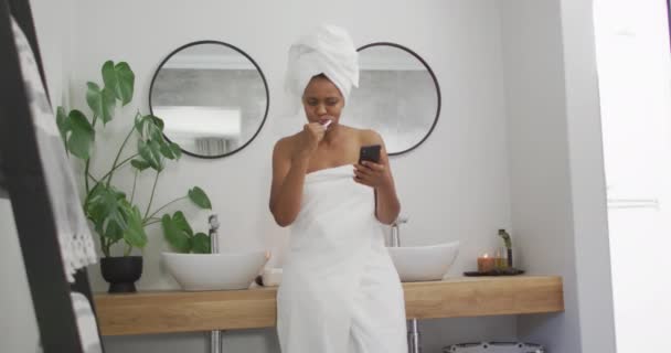 Happy African American Woman Brushing Teeth Using Smartphone Bathroom Domestic — Stock Video