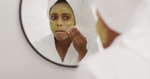 幸せなアフリカ系アメリカ人女性のバスルームで美容マスクを掃除 国内での生活や家での自由時間 — ストック動画