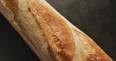 Siyah bir yüzeye yakın baget ekmeği videosu. Yemek, yemek ve yemek malzemeleri..